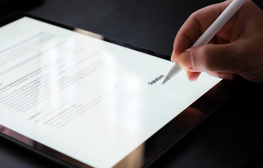 Person signing an online document on a tablet.